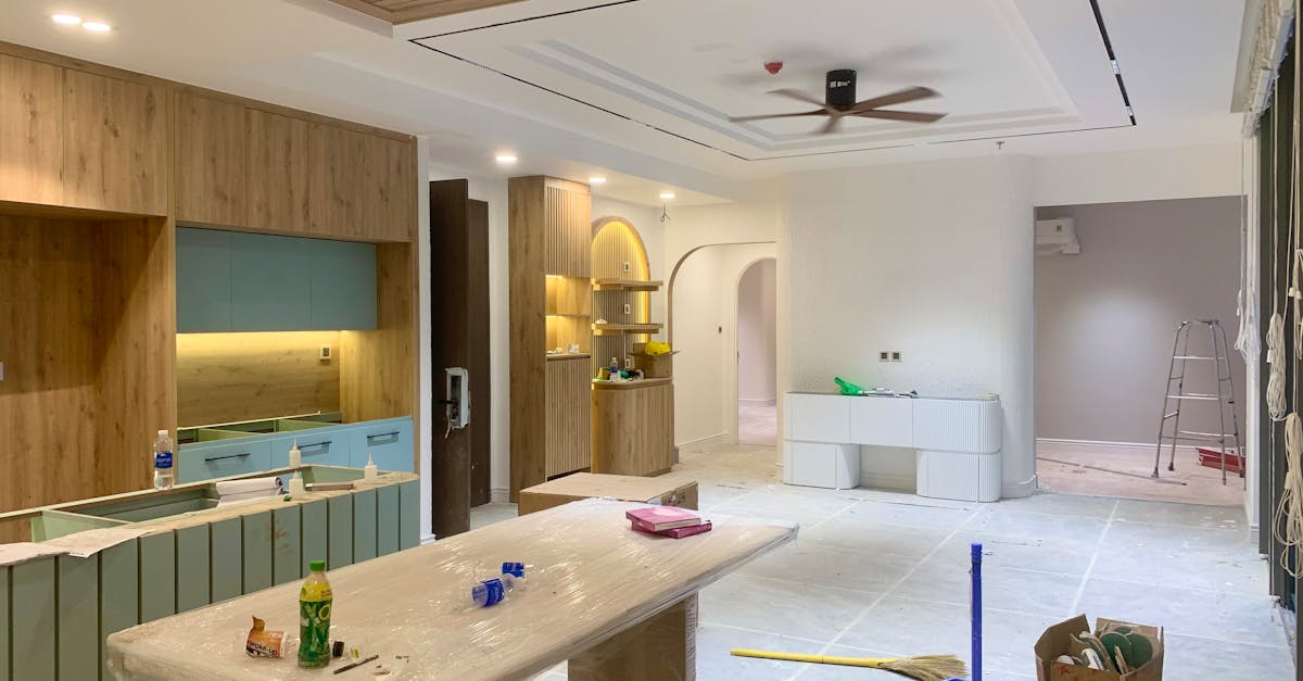 Spacious modern kitchen and dining area under renovation with wooden cupboards and stylish design.