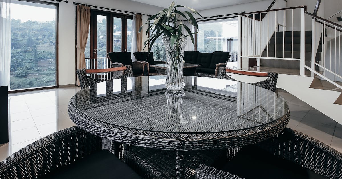 Stylish dining room in Bandung with wicker furniture and panoramic window view.