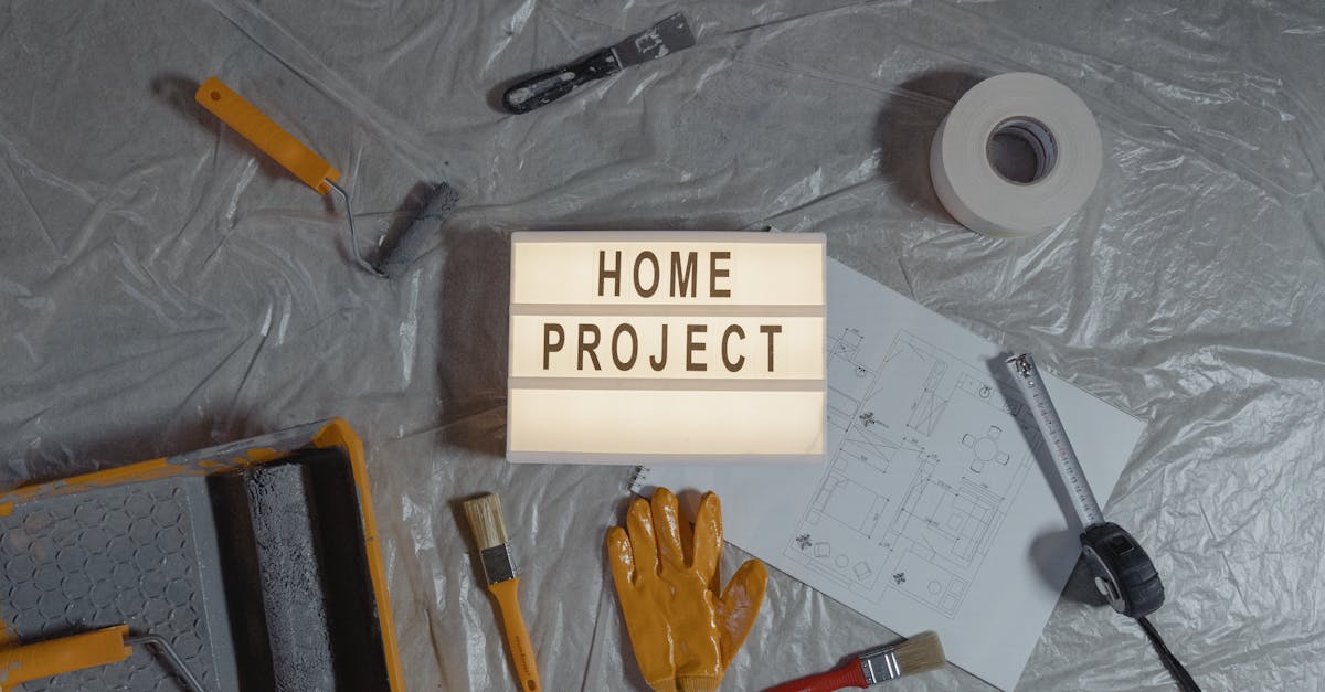 Flat lay of home improvement setup with tools, gloves, and floor plan for DIY projects.