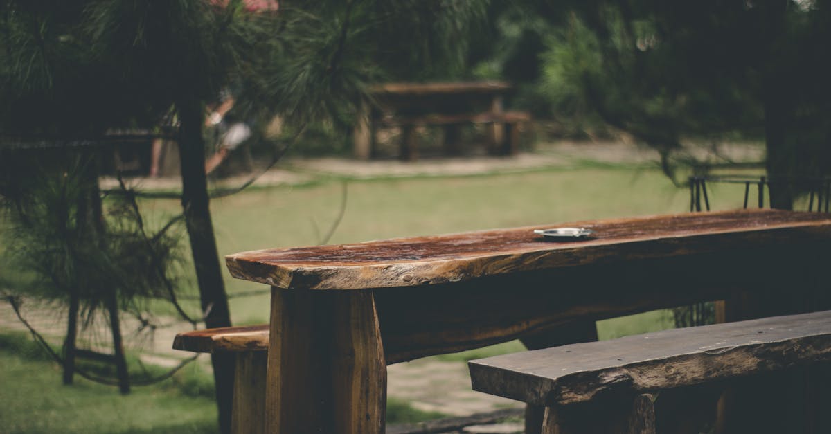 Scenic view of a rustic wooden bench in a lush green park in Cimenyan, Indonesia.