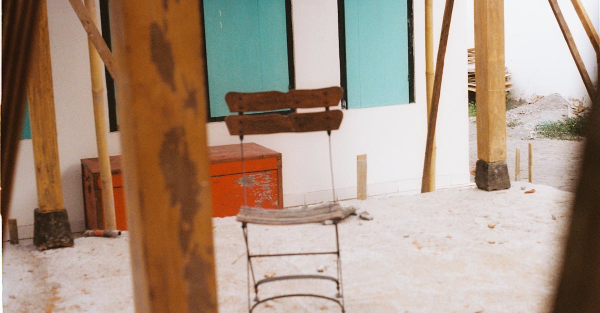 Weathered chair amidst wooden columns in a construction area, Yogyakarta, Indonesia.