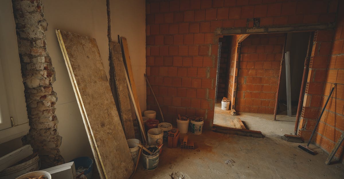 A red brick wall under construction with tools and materials scattered around in a renovation project.