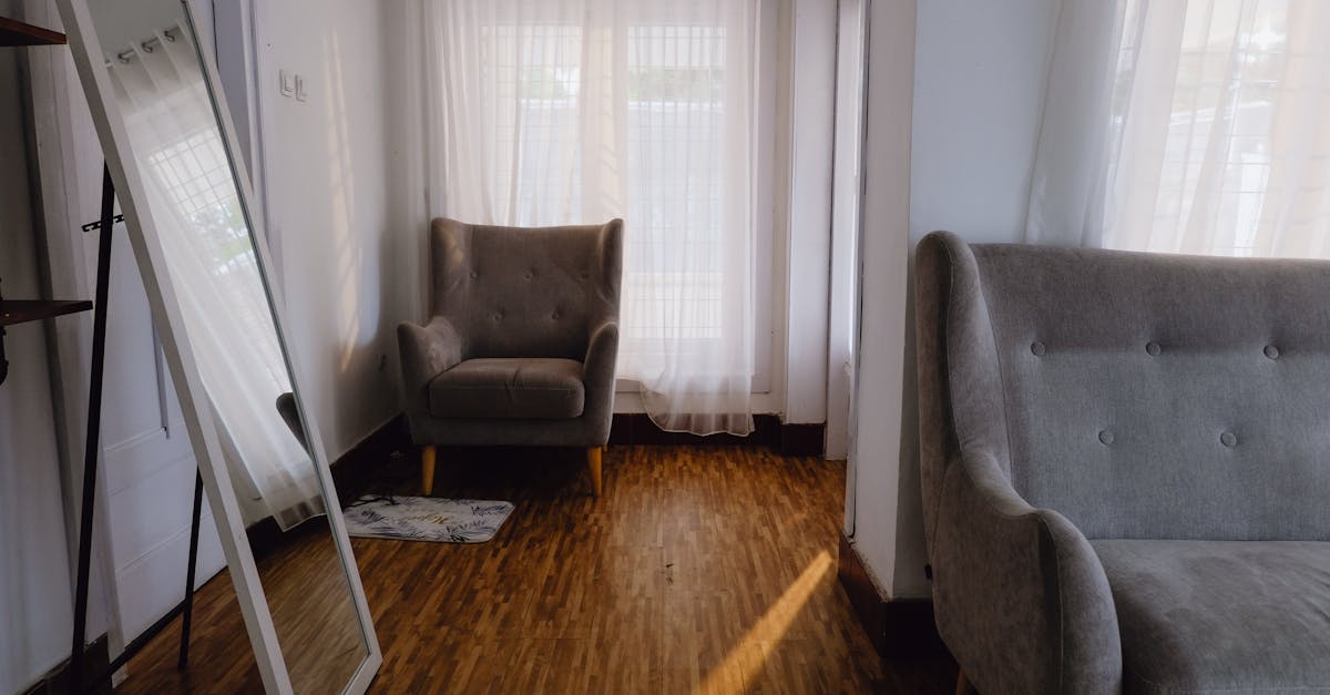 Bright and inviting living space featuring grey sofas, wooden floor, and natural light.