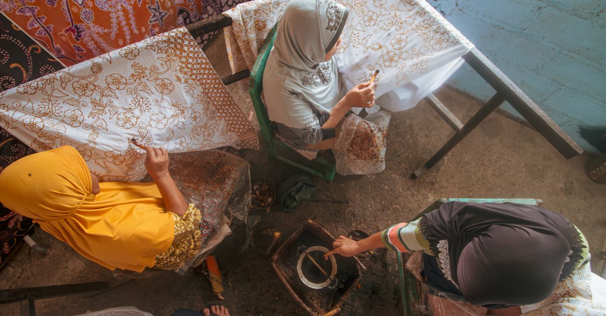 Women crafting traditional batik using wax methods in Indonesia, showcasing cultural heritage.