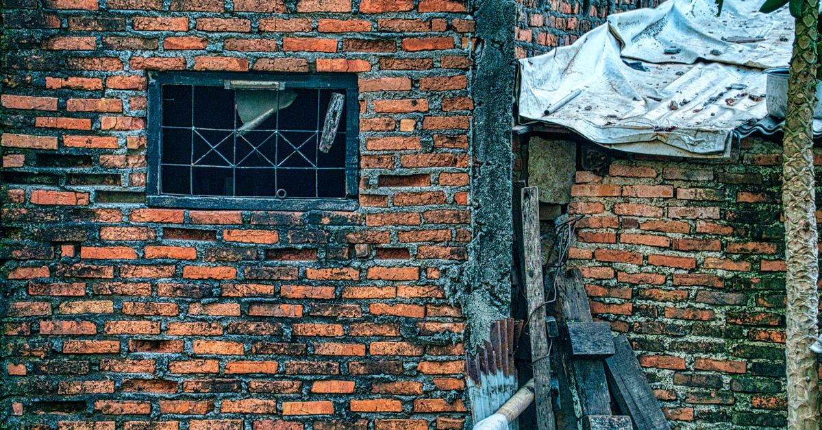 A detailed view of an old, abandoned building with a weathered brick wall in Jakarta, Indonesia.
