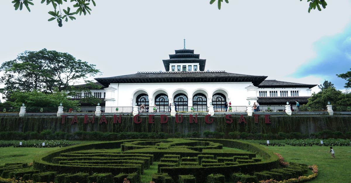 Scenic view of Gedung Sate, a historic government building in Bandung, surrounded by lush greenery.