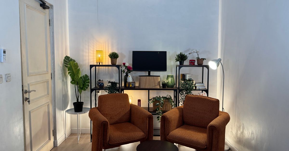Inviting home office with cozy armchairs, plants, and well-organized shelves.